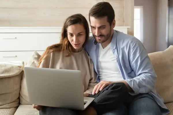 couple watching laptop and talking in good happy mood