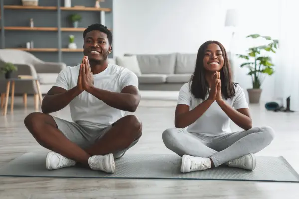 happy couple doing yoga in the morning 
