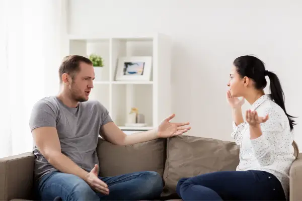 couple fighting while sitting in couch